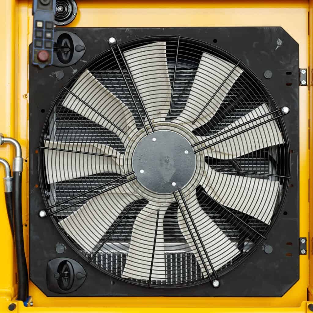 Close-up of part of huge industrial or construction machine with electric fan necessary dor cooling its engine during work